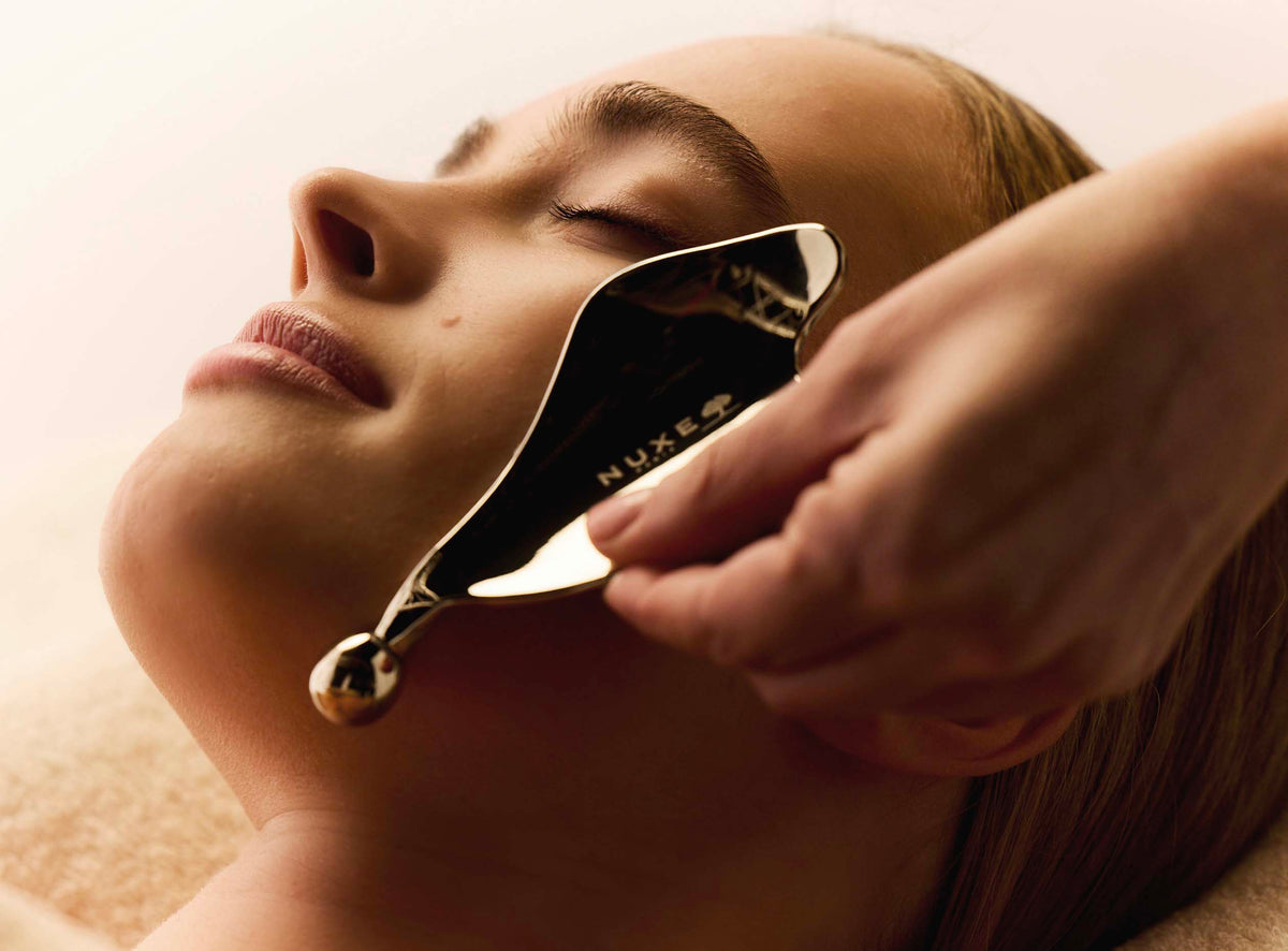 Gua sha appliqué le long de la mâchoire lors d’un soin du visage