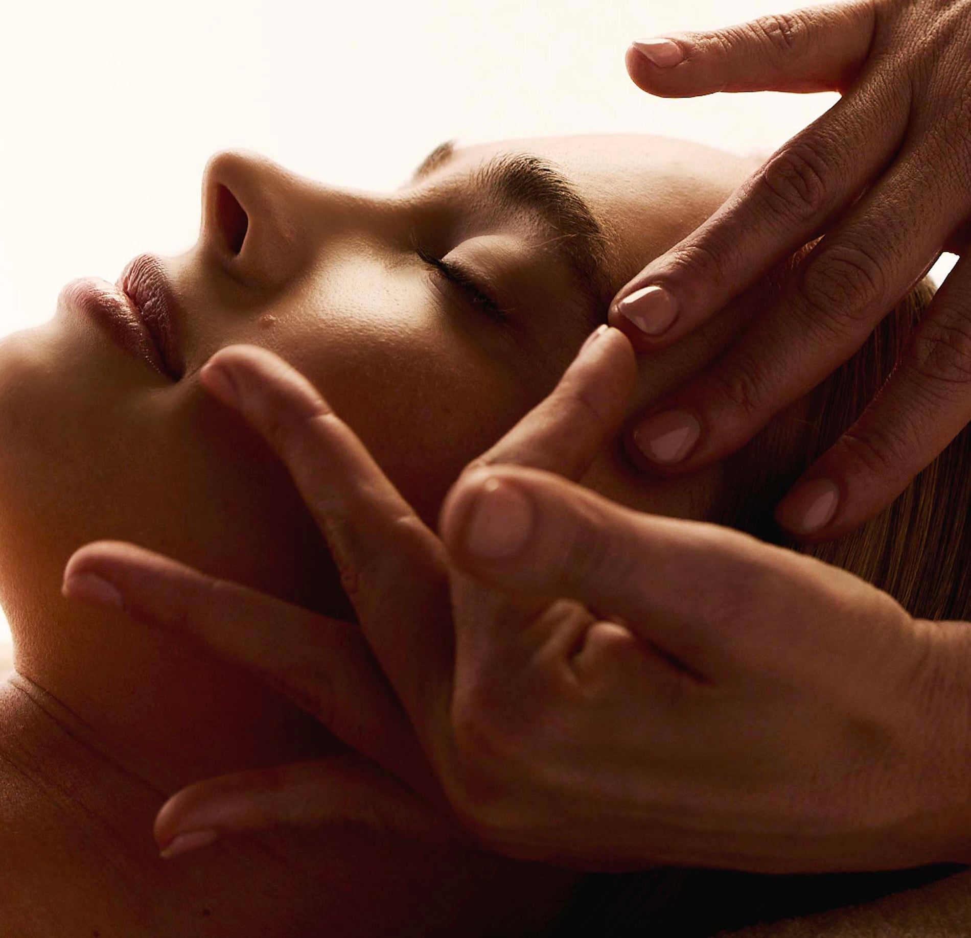 Massage du visage réalisé avec les mains d’un praticien.