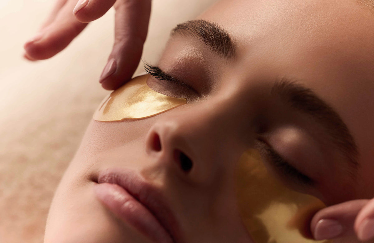 Application de patchs dorés contour des yeux lors d’un soin du visage