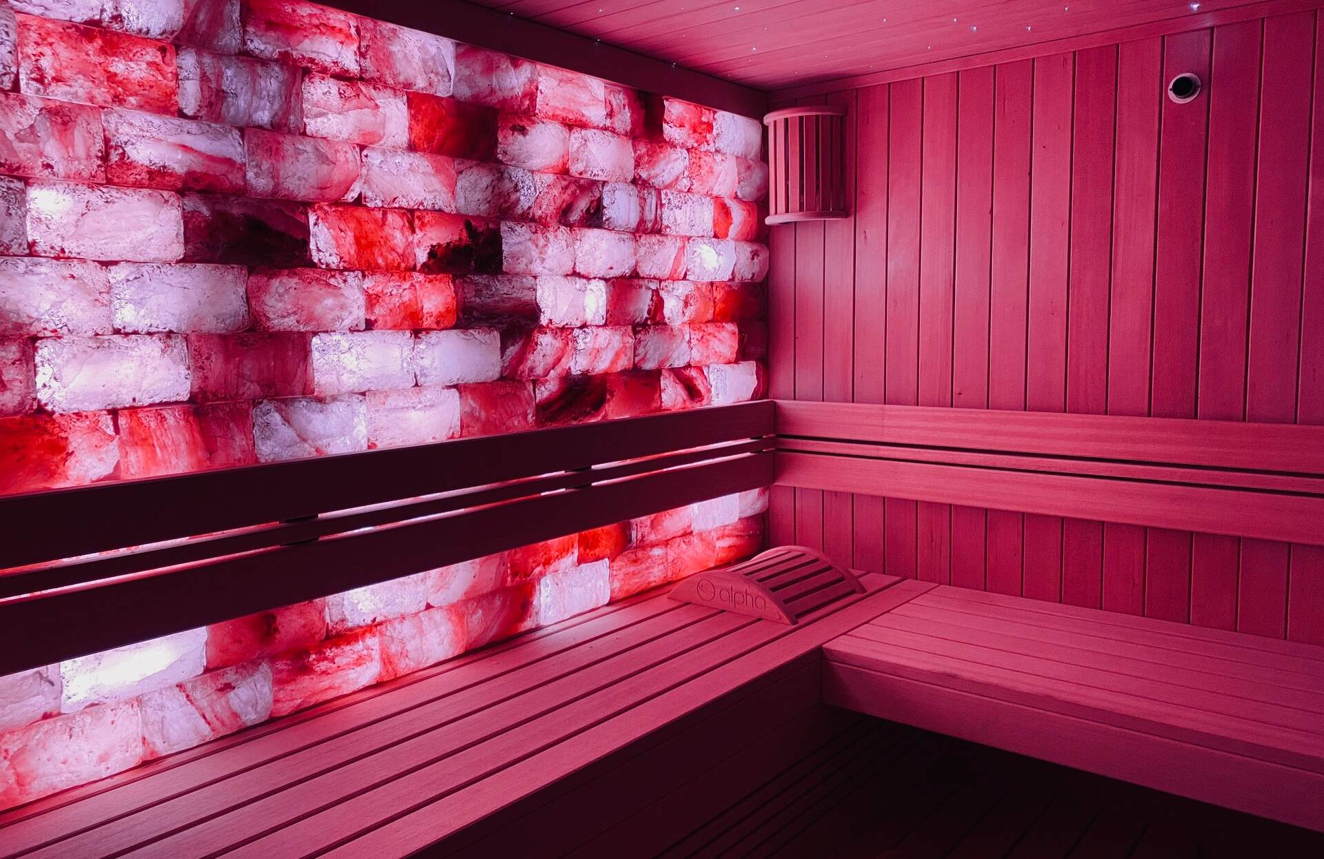 Un sauna élégant aux teintes chaleureuses, sublimé par un mur de briques de sel aux nuances rosées et lumineuses. Entre bois naturel et éclairage tamisé, cet espace enveloppant invite à une expérience sensorielle unique, propice à la détente et à la régénération.