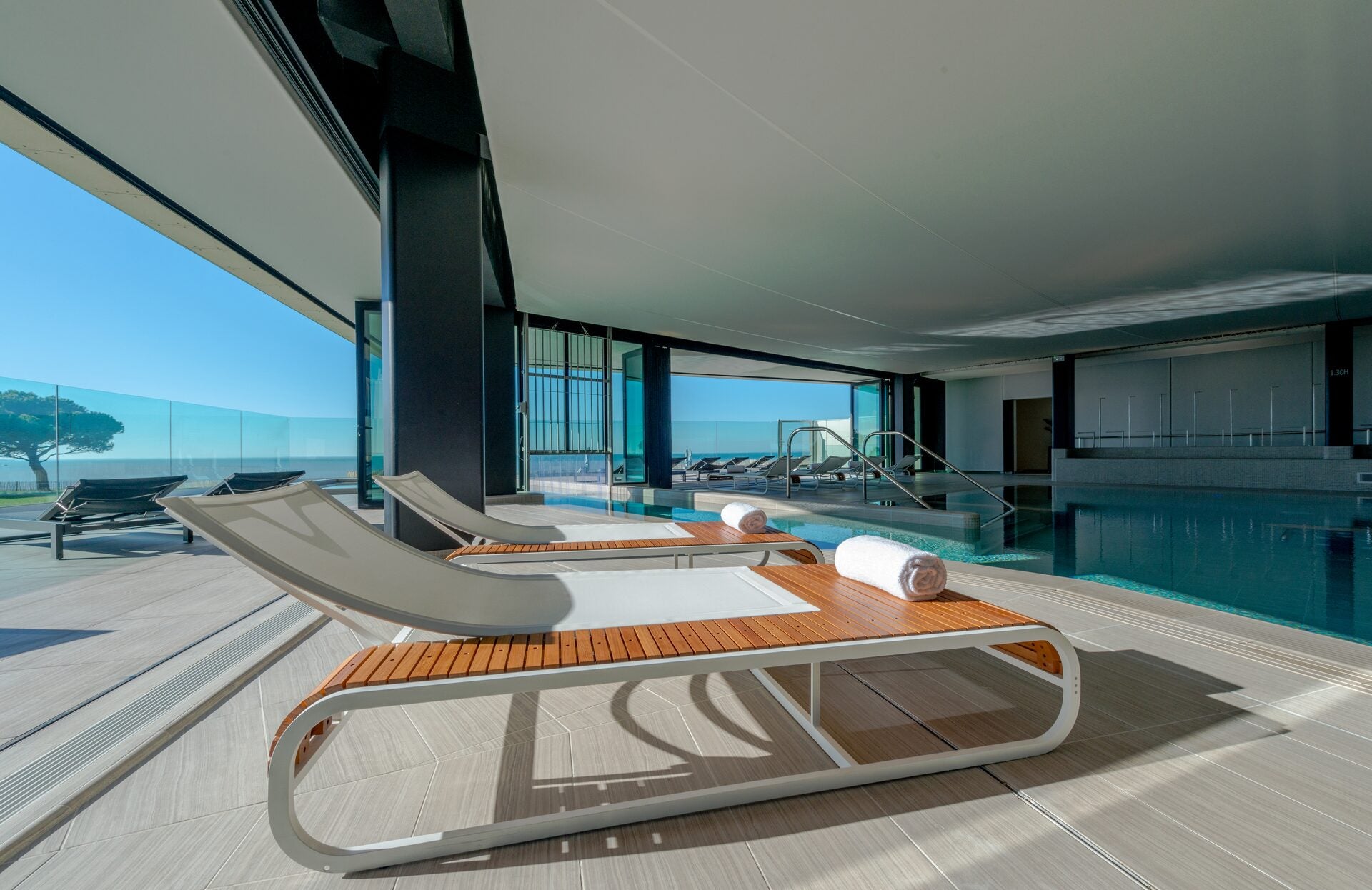 Un espace bien-être lumineux et contemporain, ouvert sur l’extérieur, invite à la détente face à une vue apaisante. Entre piscine intérieure, transats design et grandes baies vitrées, ce lieu élégant offre un cadre idéal pour se ressourcer dans une atmosphère à la fois moderne et relaxante.