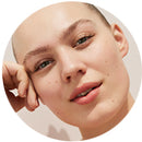visage de femme qui repose sa tête sur sa main. Elle est blonde, les cheveux tirés en arrière, et les yeux bleus.