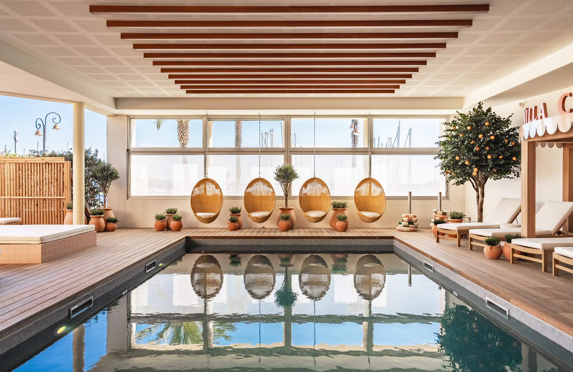 Un espace bien‑être lumineux et élégant, organisé autour d’une piscine intérieure aux reflets apaisants. Entre matériaux naturels, suspensions en rotin et larges ouvertures sur l’extérieur, ce lieu au design soigné invite à une parenthèse de détente dans une atmosphère douce et ensoleillée.