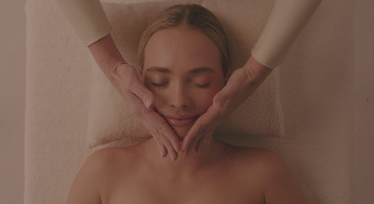 Vidéo Spa NUXE : modelages du visage et du corps, huile dorée versée dans la paume d'une praticienne, cliente détendue les yeux fermés
