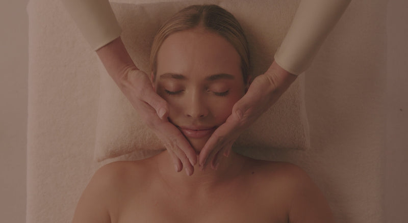 Vidéo Spa NUXE : modelages du visage et du corps, huile dorée versée dans la paume d'une praticienne, cliente détendue les yeux fermés