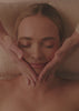 Vidéo Spa NUXE : modelages du visage et du corps, huile dorée versée dans la paume d'une praticienne, cliente détendue les yeux fermés