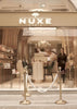 La scène s’ouvre sur une femme élégante qui franchit les portes d’une boutique NUXE située à Paris. Dès son entrée, elle découvre un univers raffiné et apaisant. Elle prend le temps d’explorer les lieux, son regard se posant sur les différentes gammes de produits mises en valeur sur les présentoirs. Les soins, nombreux et variés, reflètent l’expertise et le savoir‑faire de la marque.
Progressivement, elle se dirige vers l’espace spa, attirée par l’ambiance calme et relaxante qui s’en dégage.